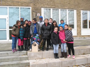 Ett antal flickor och pojkar på trappan till skolan. 