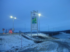 En skylt där man ser bron över till Finland i bakgrunden
