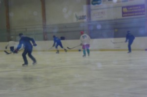 Tre ungdomar som spelar hockey
