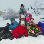 Nallen tillsammans med skolbarn i ett snöklätt vinterlandskap