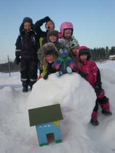 Utomhusbild med barnen och nallen i en massa snö
